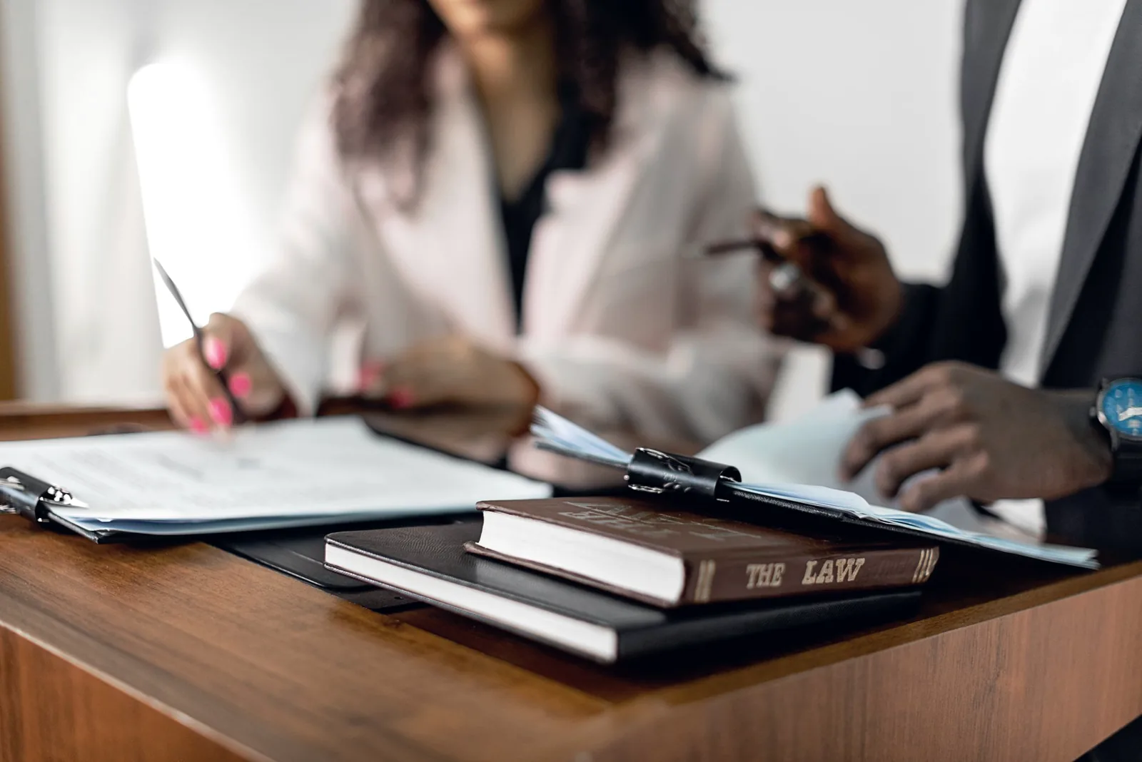 Deux juristes relisent des actes devant des ouvrages de droit