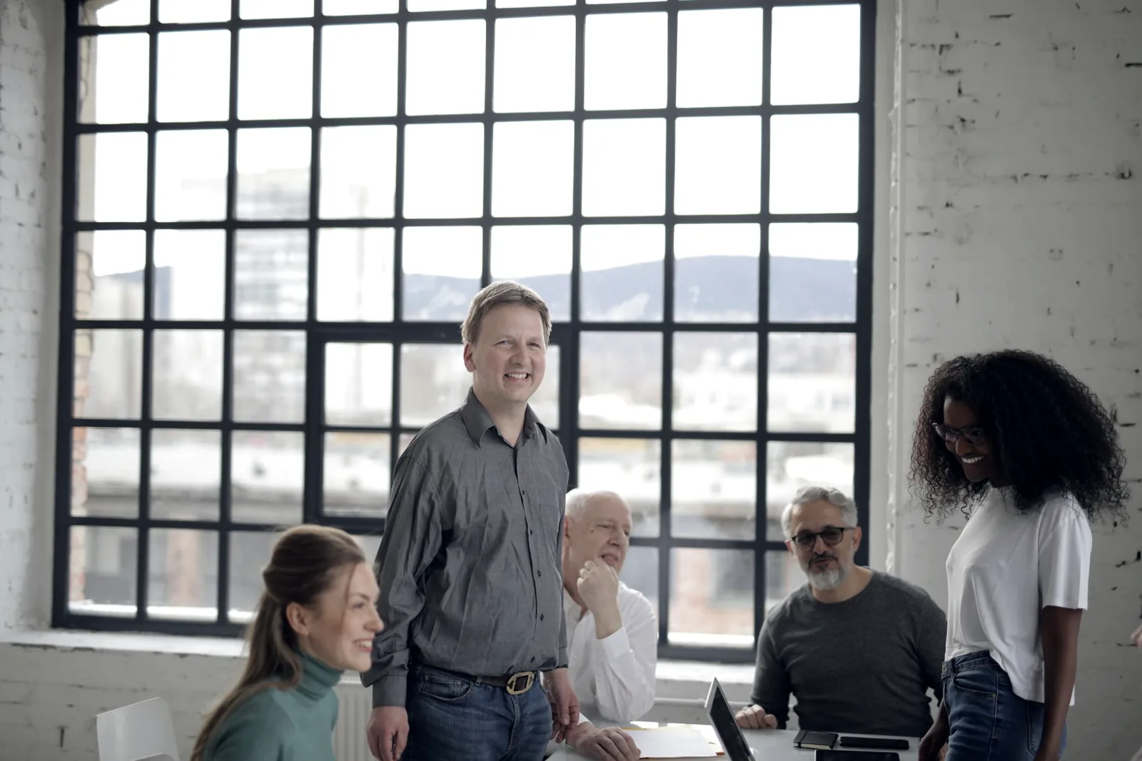 Une équipe de collaborateurs de tous âges échange autour d’une table